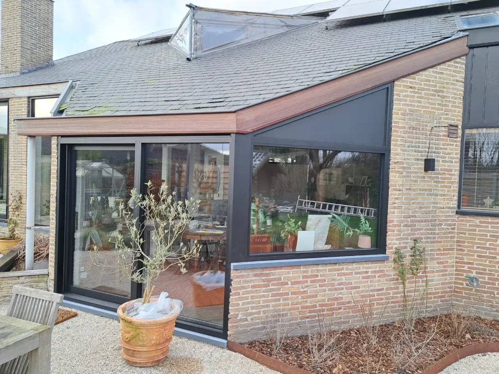 Aanbouw met zwart aluminium schuifraam en padoek dakrand