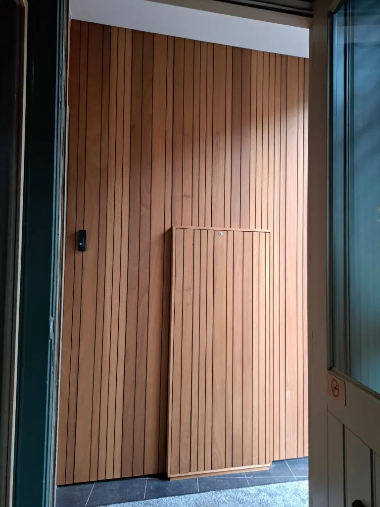 Wandbekleding in verticale houten latten met geïntegreerde kast